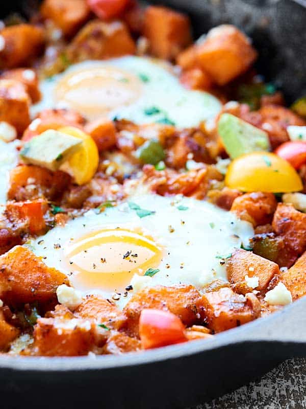 Close-up image of egg on top of sweet potato hash