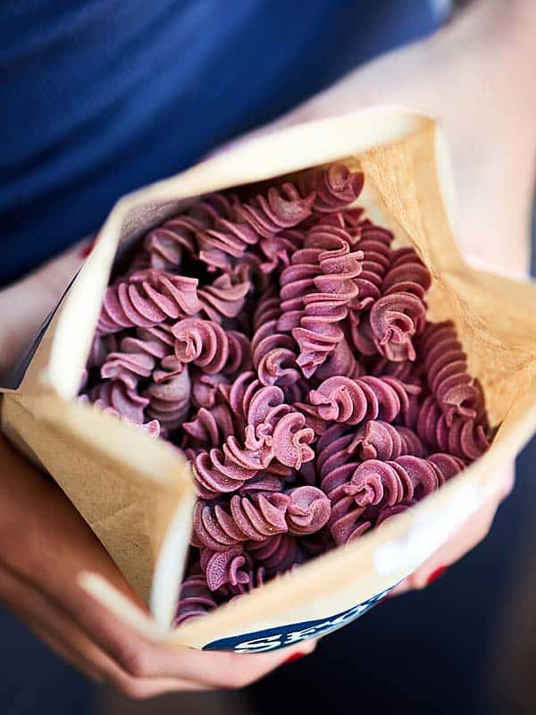 geopende verpakking van bieten pasta hierboven gehouden