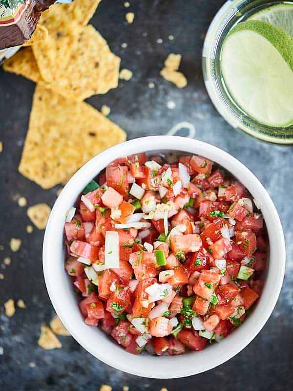 This Easy Pico de Gallo Recipe comes together in a matter of minutes! Fresh tomatoes, onion, cilantro, jalapeno, lime, & garlic make this truly delicious. showmetheyummy.com #picodegallo #healthymexicanfood