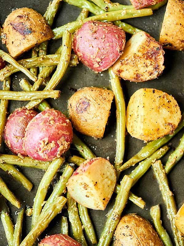 Potatoes and green beans on baking sheet above