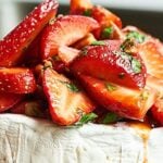 This Strawberry Baked Brie is the easiest appetizer for spring! Warm brie is topped with strawberries, basil, pecans, & a simple balsamic/honey marinade. showmetheyummy.com #brie #bakedbrie