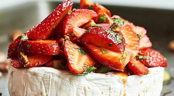 This Strawberry Baked Brie is the easiest appetizer for spring! Warm brie is topped with strawberries, basil, pecans, & a simple balsamic/honey marinade. showmetheyummy.com #brie #bakedbrie