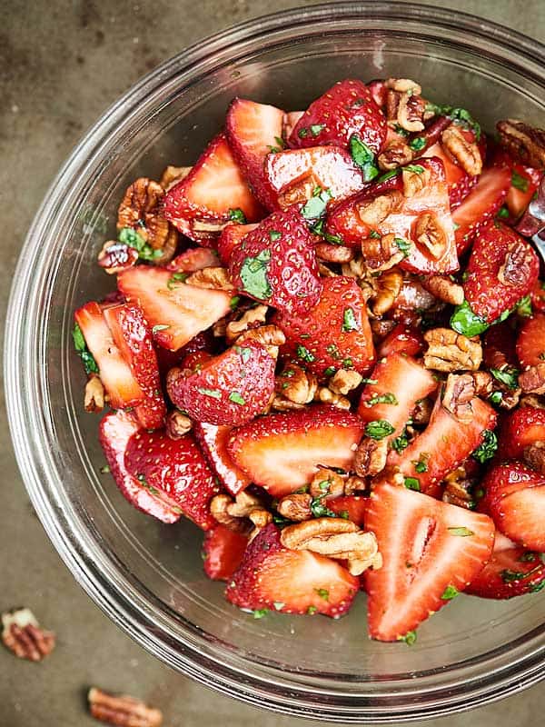 strawberries and dressing in mixing bowl above