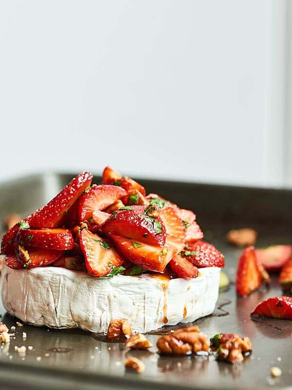 baked brie piled with strawberry slices side view