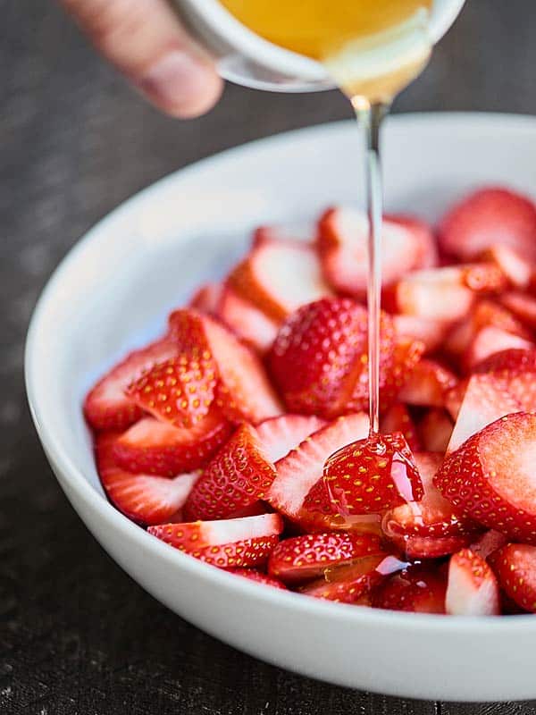 agave being drizzled over strawberries