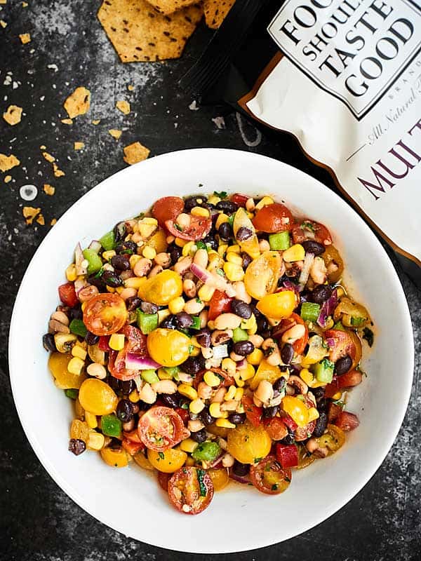 Ready for the easiest Cinco de Mayo recipe? This Texas Caviar comes together in a matter of minutes and is full of fresh veggies - peppers, onion, tomatoes - beans, corn, and a tangy dressing! showmetheyummy.com #texascaviar #cincodemayo