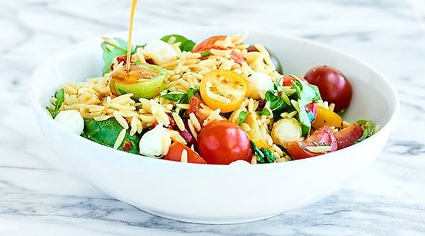 This Caprese Pasta Salad is so quick and easy to put together! Full of orzo pasta, mozzarella, sun dried tomatoes, fresh basil, tangy balsamic, and salty parmesan! showmetheyummy.com #pastasalad #caprese