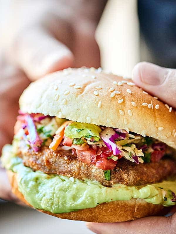 Mexican turkey burger held two hands