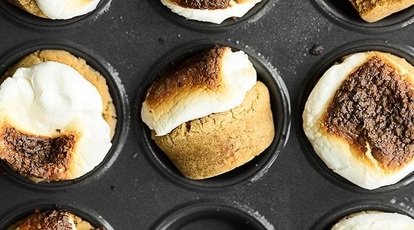 SMores Cookie Cups. A simple graham cracker cookie is stuffed with a melty hershey’s kiss, topped with a marshmallow, and gets toasted to golden perfection! showmetheyummy.com #smores #cookie