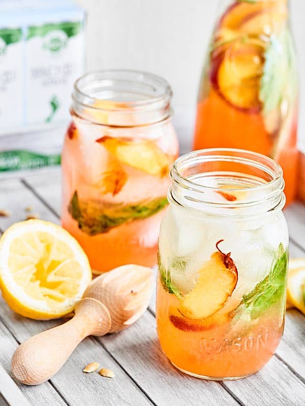 A refreshing adult's only cocktail, this Peach Lemonade Spritzer is made with fresh peaches, tart lemons, earthy basil, vodka, and a crisp white wine spritzer! showmetheyummy.com Recipe made in partnership with @BarefootWine #ad #cocktail