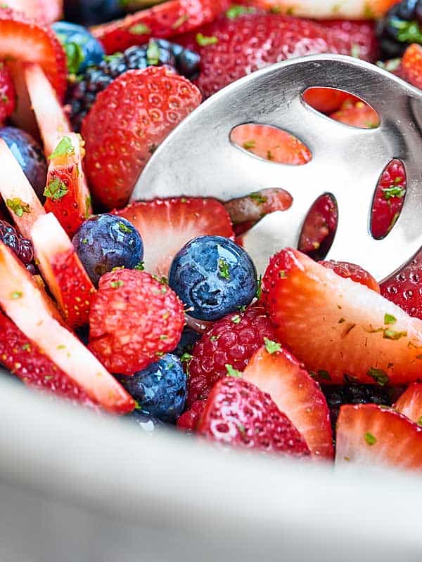 Closeup of spoon in berry fruit salad