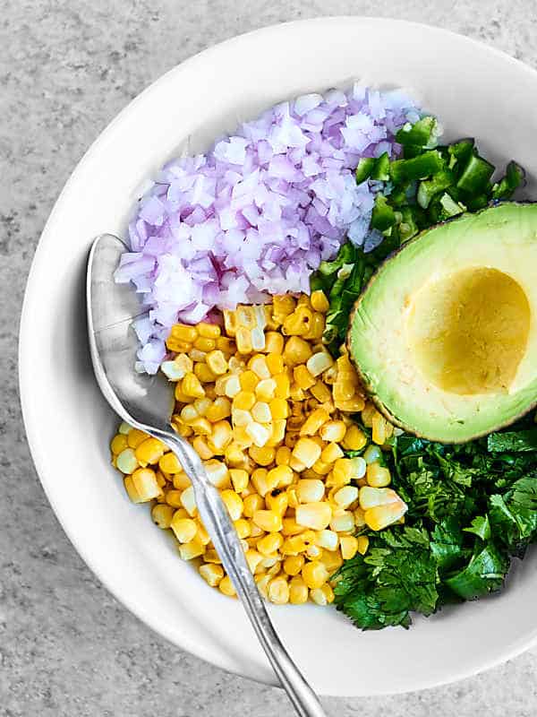 bowl of avocado, corn, onions, and cilantro