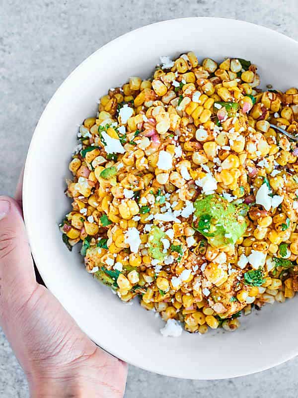 bowl of mexican corn salad above held