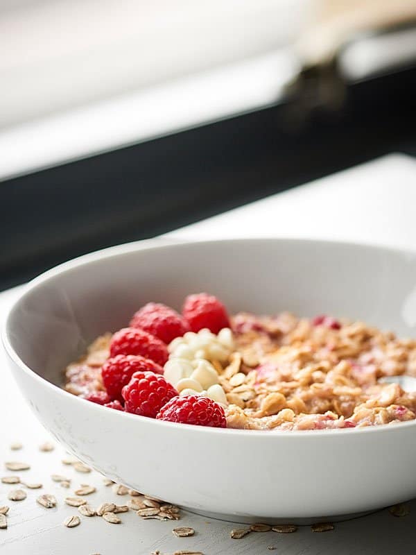 bowl of oatmeal with berries and white chocolate chips side