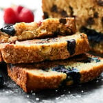 Full of fresh blueberries, raspberries, and dark chocolate chips, this Berry Banana Bread is loaded with goodness and is the perfect breakfast, snack, or dessert! showmetheyummy.com Recipe made in partnership w/ @DriscollsBerry #finestberries #bananabread