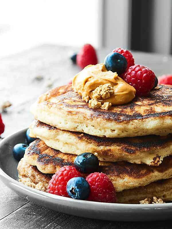 stack of buttermilk pancakes with peanut butter and berries