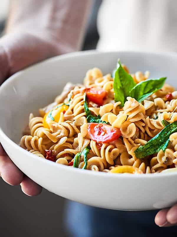 bowl of caprese mac and cheese held two hands