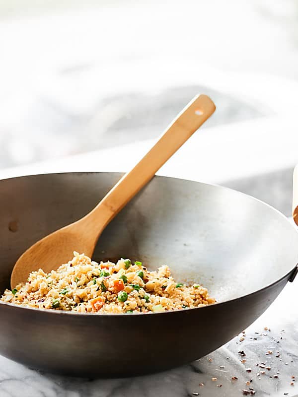 wok with cauliflower fried rice and wooden spoon