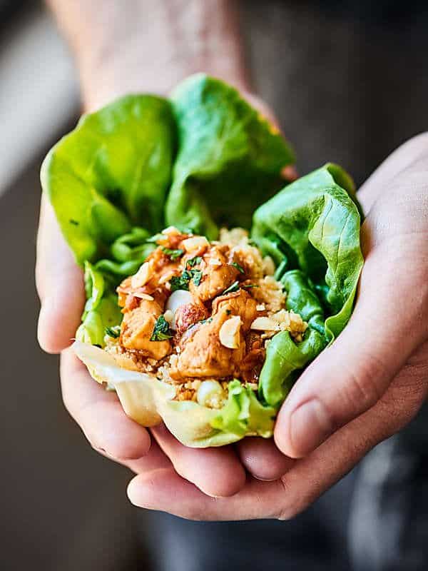 Healthy asian lettuce wrap held in two hands