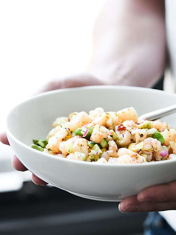 bowl of shrimp avocado salad held