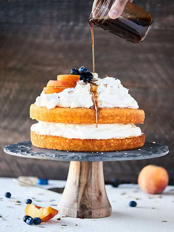 chardonnay caramel cake on cake stand being drizzled with caramel