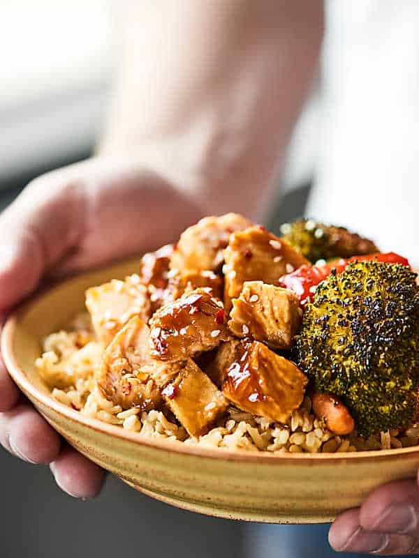 Plate of teriyaki turkey tenderloin with veggies and brown rice being held