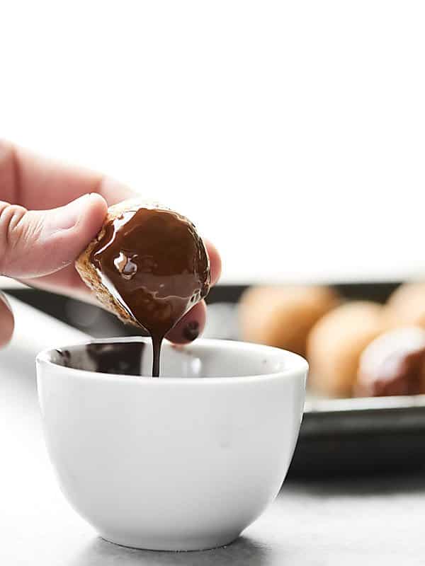 lara bar bite being dipped in bowl of melted chocolate