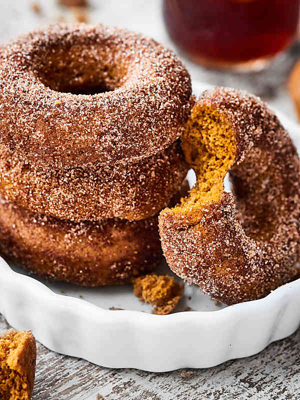 baked pumpkin donuts stacked on plate 