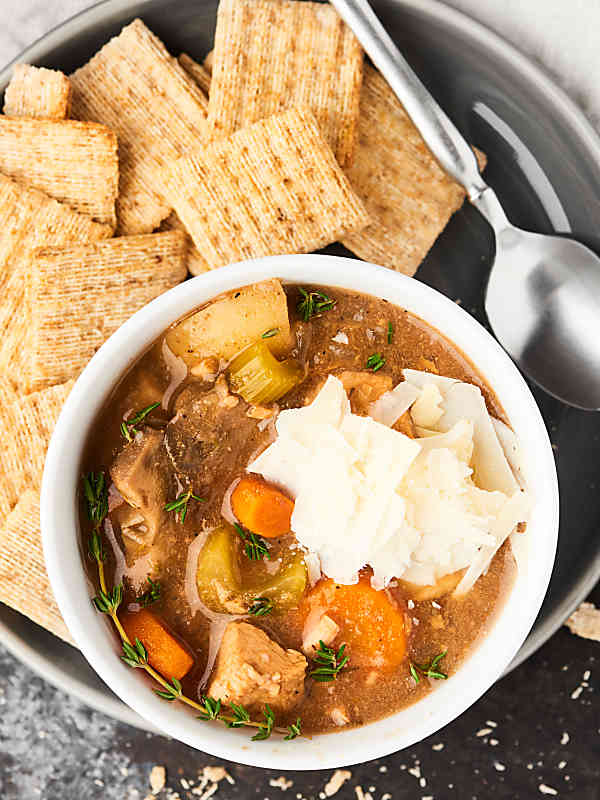 Turkey stew in bowl on plate with crackers
