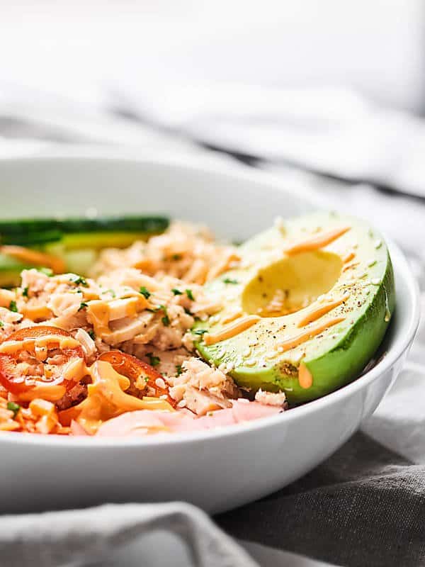 Spicy tuna sushi bowl with half avocado side view