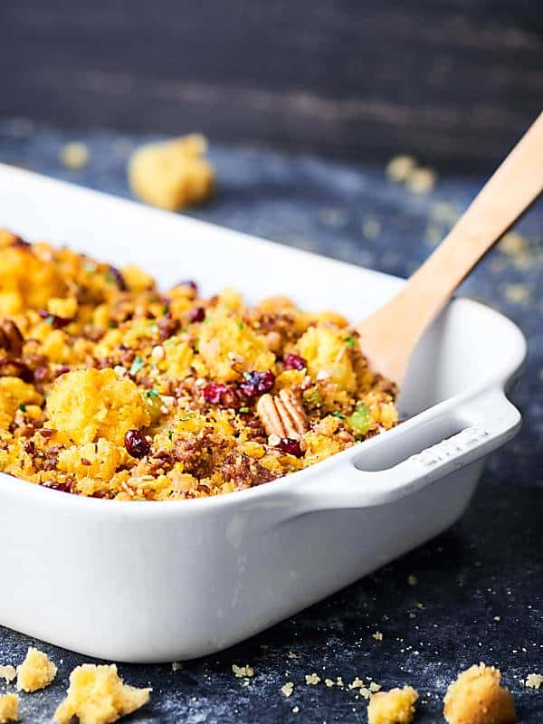 wooden spoon in baking dish with cornbread dressing