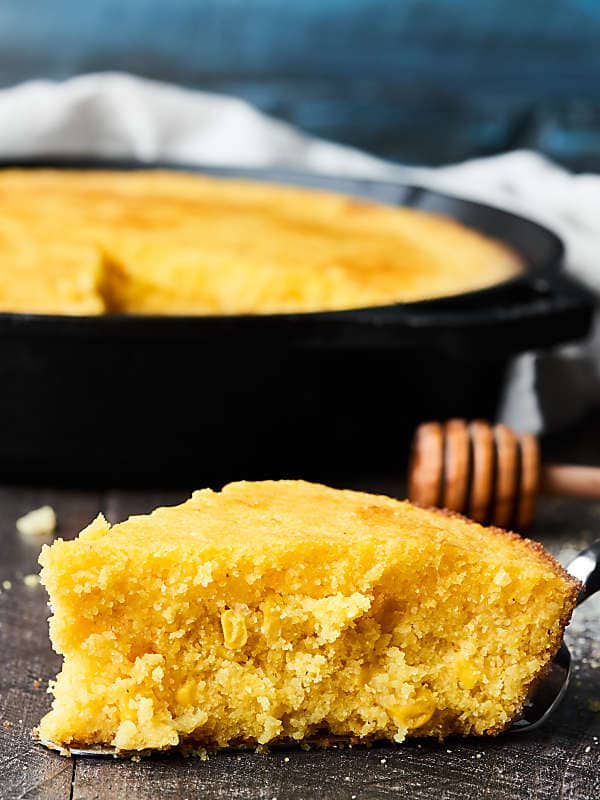 Slice of cornbread with skillet in background