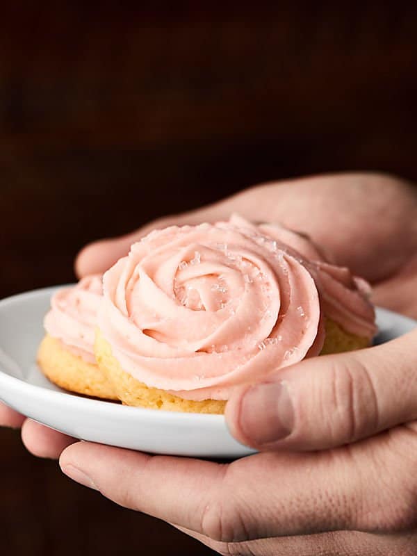 champagne sugar cookies with champagne frosting on plate held