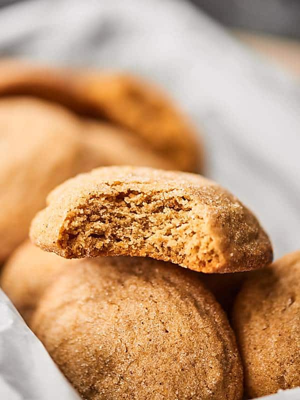 chewy ginger cookie stacked on basket with others, bit taken out