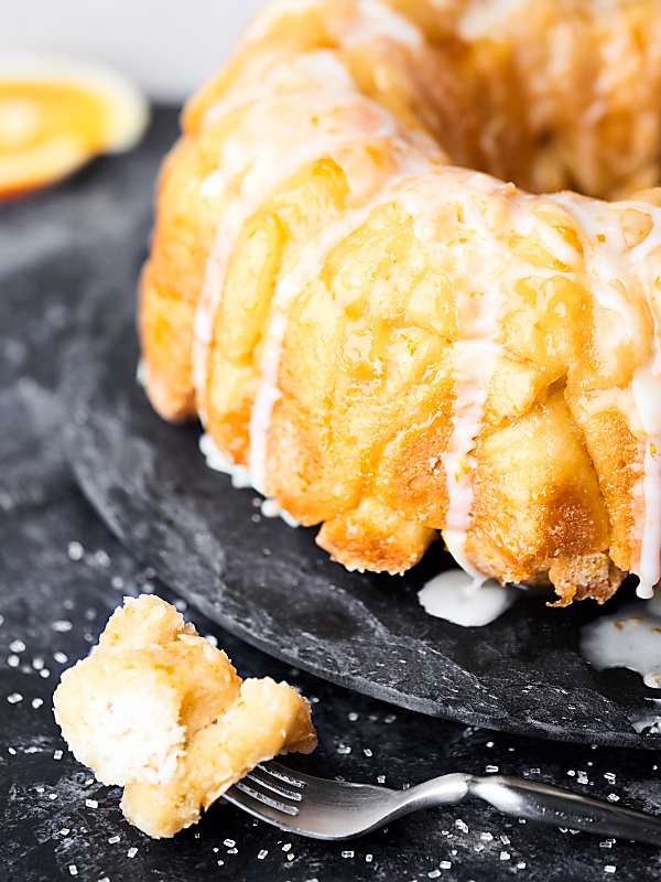 bite of mimosa monkey bread on fork next to whole loaf
