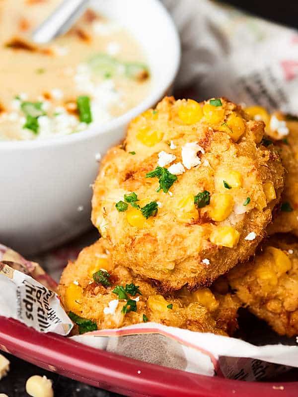 baked corn crab cakes next to bowl of soup in basket