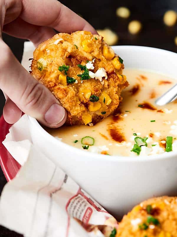 corn crab cake dipped into bowl of soup