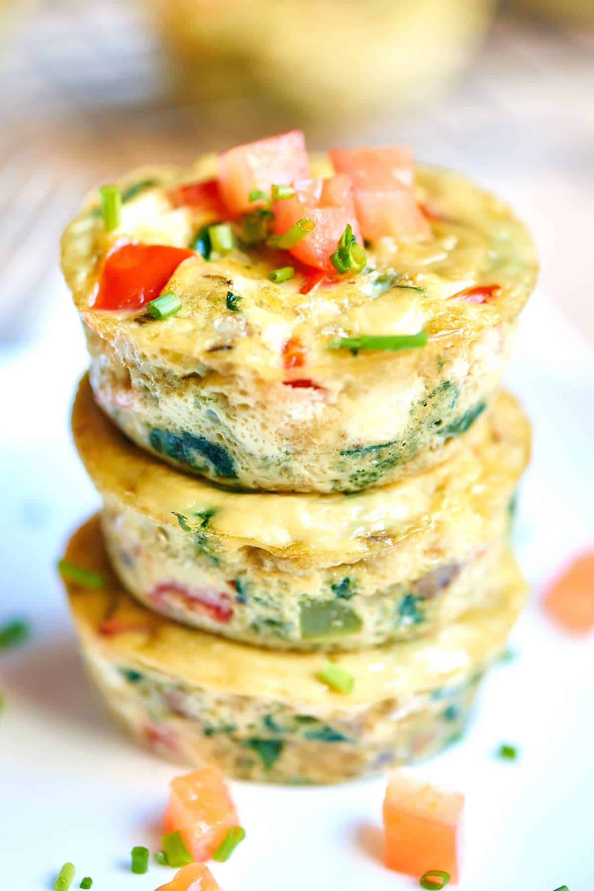 healthy egg muffin cups stacked and topped with tomato