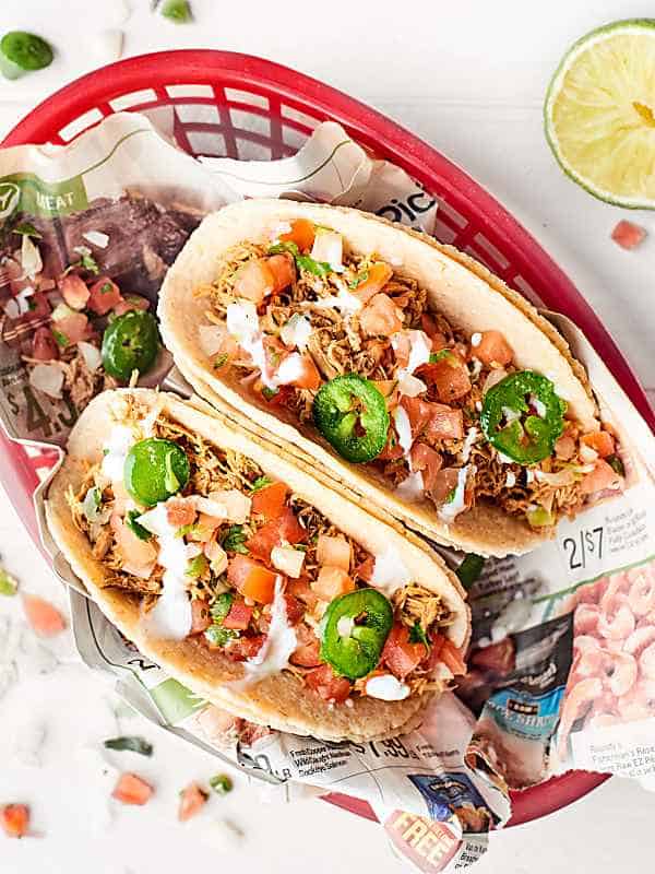 Mexican chicken on taco shells in basket above