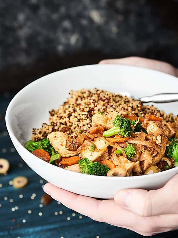 bowl of moroccan chicken held two hands