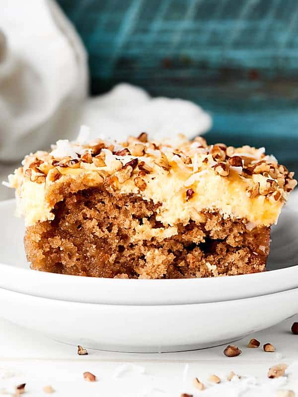 Cake mix kicked up a notch to make this Carrot Poke Cake Recipe! Carrot cake is drizzled with cream of coconut then smothered in a homemade caramel cheesecake cool whip frosting. showmetheyummy.com