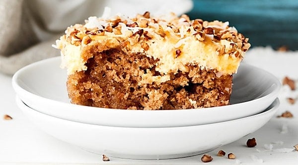 Cake mix kicked up a notch to make this Carrot Poke Cake Recipe! Carrot cake is drizzled with cream of coconut then smothered in a homemade caramel cheesecake cool whip frosting. showmetheyummy.com