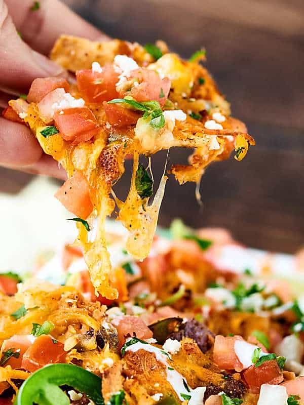 These Loaded Chicken Nachos have 12 layers! and are full of tender veggies, flavorful chicken, beans, corn, and TONS of cheese. Surprisingly quick, easy and delicious! showmetheyummy.com