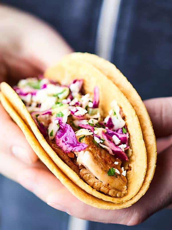 Healthy Baked Fish Tacos! Tilapia + spices + loads of lime all piled into a corn tortilla and topped with a fresh, crunchy slaw! Healthy easy deliciousness for the win! showmetheyummy.com