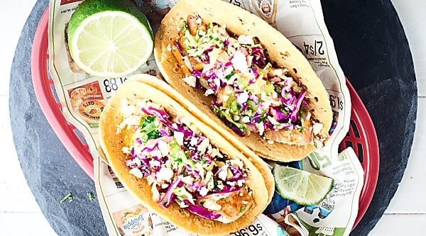 Healthy Baked Fish Tacos! Tilapia + spices + loads of lime all piled into a corn tortilla and topped with a fresh, crunchy slaw! Healthy easy deliciousness for the win! showmetheyummy.com
