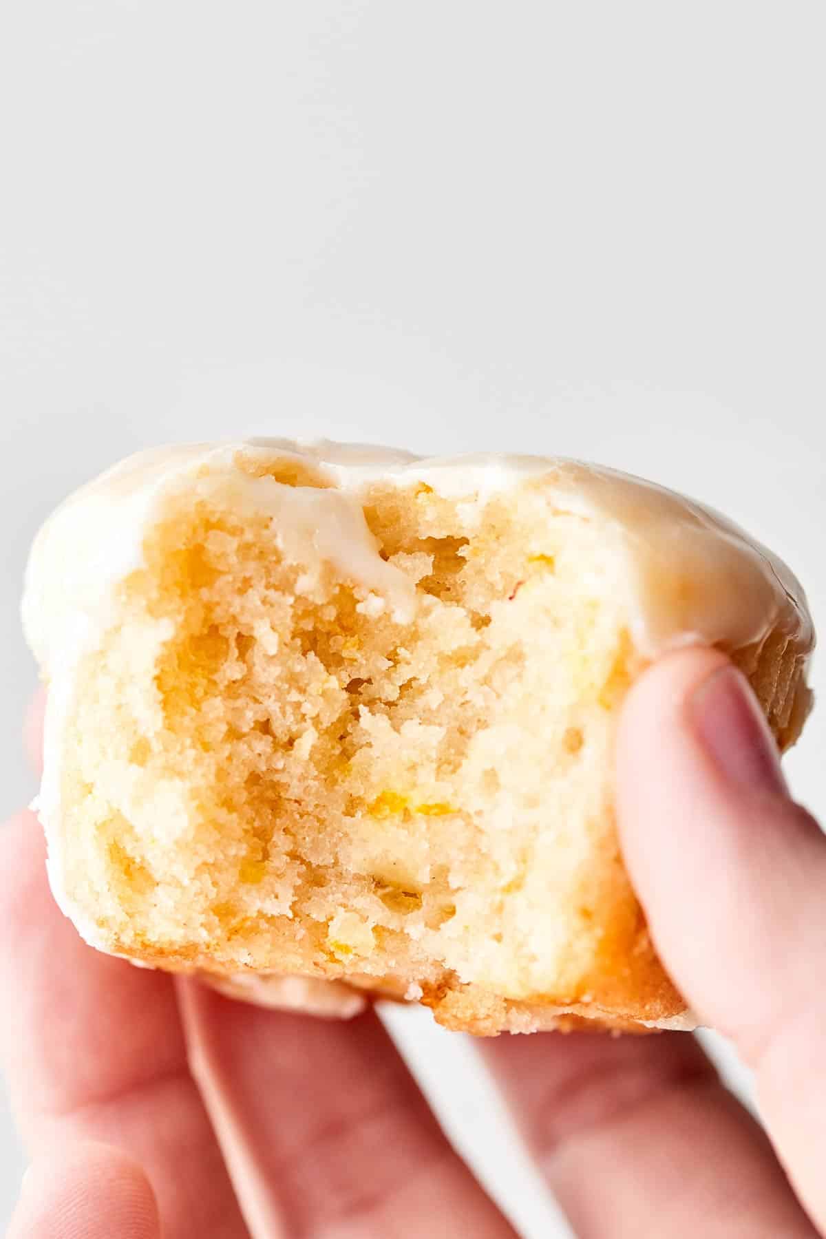 Vegan lemon pound cake cupcake with bite taken out held