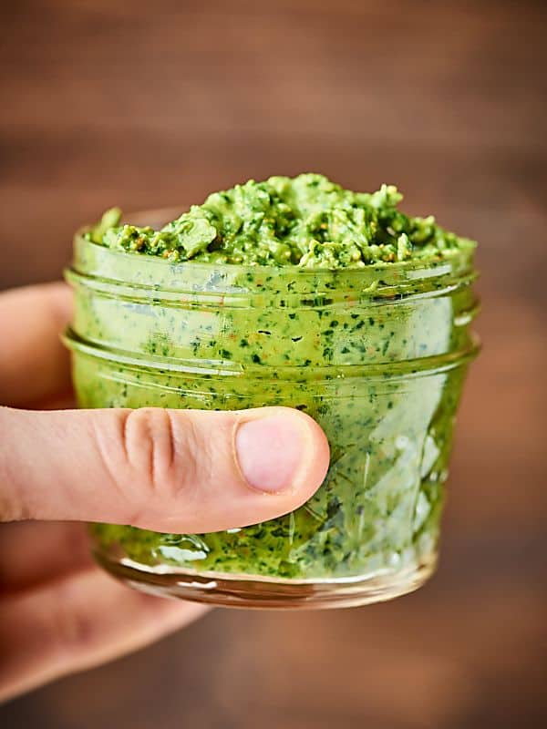 Jar of avocado pesto held