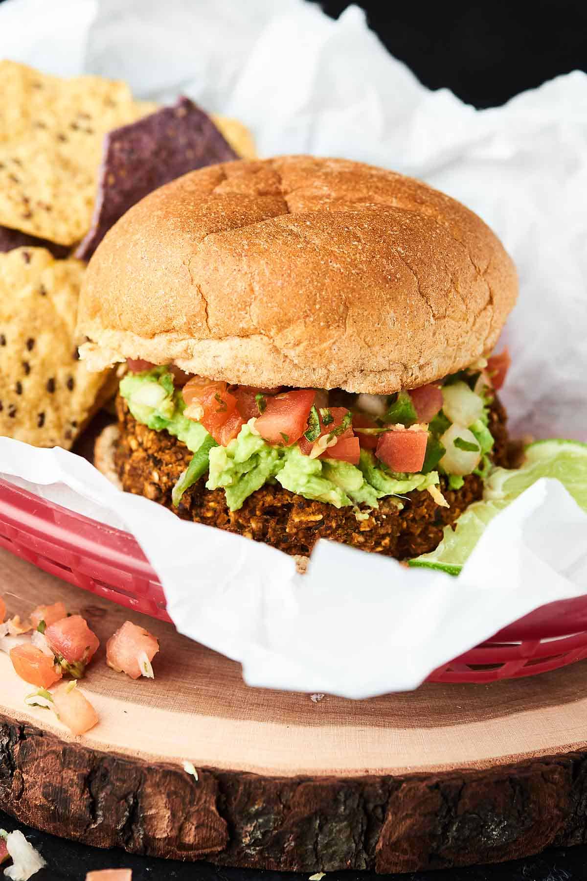 Black bean burger on bun in basket with crackers