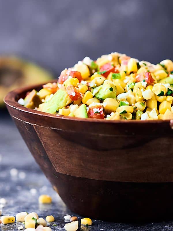 Bowl of grilled corn avocado salsa side view