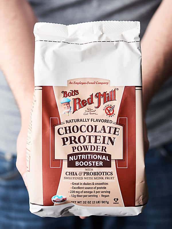 package of chocolate protein powder held